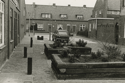 195970 Opgeknapte huizen, in de straat plantenbakken gemaakt van bielzen, 1978