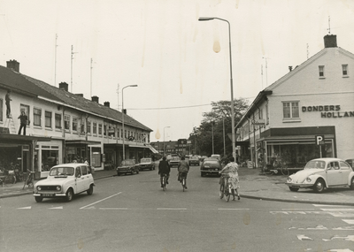 195995 Winkelstraat met fietsers en auto's, ter hoogte van de Roostenlaan, rechts schoenwinkel Donders op nummer 15, ...