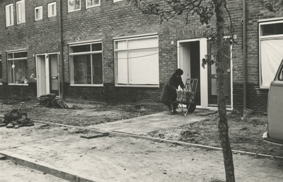 196005 Vrouw laadt stenen op een kruiwagen, straat niet bekend., 1979