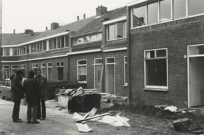 196036 Het overleg van drie mannen voor de te renoveren huizen, 1977