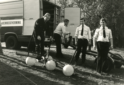 199313 Het gereed maken van het materieel door brandweermannen, op de achtergrond een bestelbus met oplegger, 13-10-1978