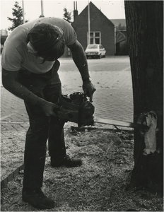 251613 Het omzagen van een boom door een medewerker van de Plantsoenendienst, 1975 - 1980