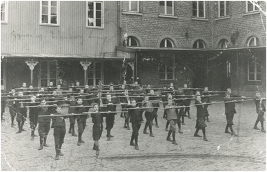 191 De leerlingen van Pensionaat Eikenburg krijgen gymnastiekoefeningen op de binnenplaats. Één van de jongens is W.van ...