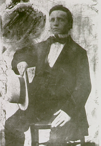 1697 Henricus Vrijdag: kantoorbediende, zittend op een stoel met hoed in de hand, ca. 1870
