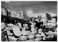 2631 Verkoopruimte van warenhuis HEMA: toonbank met uitstalling serviesgoed en winkelmeisjes, 20-11-1937