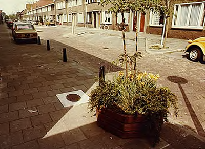 8512 Een straat in de Kruidenbuurt met op de voorgrond 'n plantenbak, geplaatst in het kader van 'n herinrichtingsplan, ...