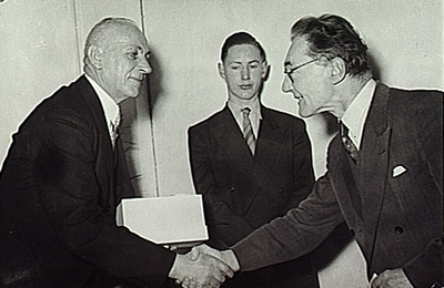 8820 Het 40-jarig ambtsjubileum van W.J. Smulders, hoofd militaire zaken; in het midden de zoon van de jubilaris, 1954