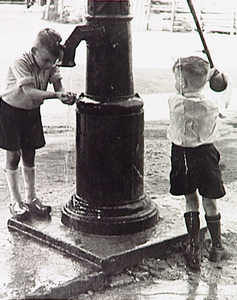 20318 Kinderen bij de waterpomp voor het raadhuis op de Markt, links R. de Kok, rechts Leo de Bresser, 1960
