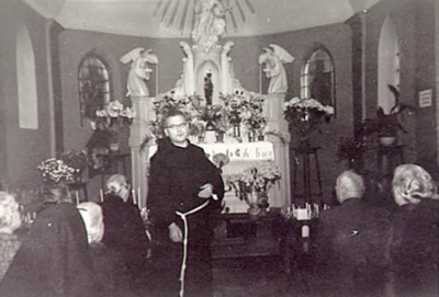 22539 Pater van Genuchten, ex-gevangene uit Dachau, in de kapel van de H.Eik, bij de herdenking van 10 jaar bevrijding, 1955