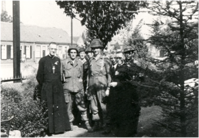 64589 Pastorietuin St. Jorisparochie: militairen van 101 Airborne Divisie met pastoor Sicking (links), 18-09-1944 - ...