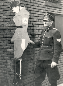 64843 Grote Berg, binnenplaats politiebureau: agent Lutke Schipholt met een kartonnen voorstelling van Hitler hangend ...