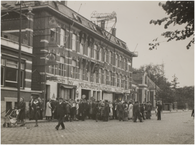 69126 Bevrijding van Eindhoven: menigte voor autogarage N.V. Van der Meulen-Ansems. Een dag later werd het pand ...