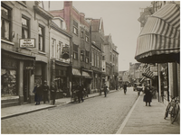 69347 De Vrijstraat met linksvoor kapperszaak L. Reemers en fruit- en groentenwinkel H. van Rijt, op nr. 13 en 15, ca. 1935