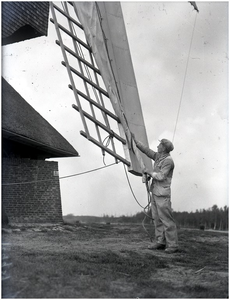 128240 Werkzaamheden bij de Heimolen, Leenderweg. De molenaar spant de zeilen op de wieken van de molen, 10-05-1938