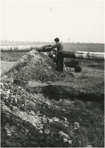 130559 Agrarische omgeving: Aanleg aardgasleiding in de gemeente Veldhoven, in de verte de kerktoren van d'Ekker, 1968