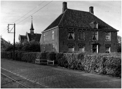132295 Predikantswoning (1770), op de achtergrond de Hervormde Kerk, Broek (Dorpstraat), 1931