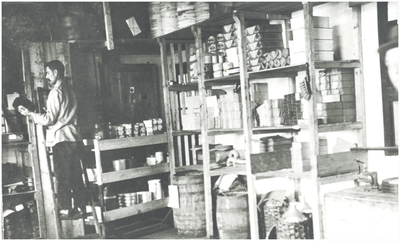 133314 Het productieproces in Schoenfabriek van der Sanden-Hoogenbosch: opslagruimte, medewerker op een ladder, 1921 - 1929