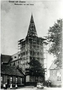 133427 R.K. kerk H. Willibrodus in de steigers tijdens de restauratie van de toren. Links café J. Keeris rechts de oude ...