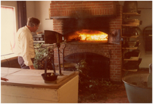 146167 Het oppoken van het vuur in de oven door een bakker van het bakkerijmuseum De Grenswachter , ca. 1985