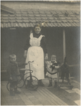 188859 Kindermeid met twee kinderen, een driewieler en hobbelpaard, 1920 - 1930
