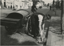 191850 Het schoonvegen van de straten met bezem, blik en handkar door een medewerker van de reinigingsdienst, 1944