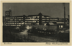 194126 Avondopname van het fabriekscomplex van Philips NV aan de Parallelweg (nu Mathildelaan), met op de voorgrond de ...