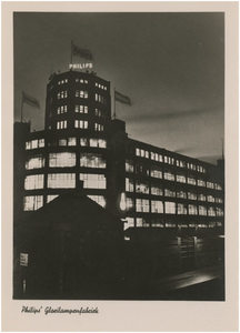 194179 Avondopname van de Lichttoren en het bedrijvencomplex van Philips NV op de hoek Emmasingel-Mathildelaan, ca. 1955