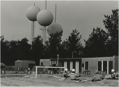 195051 Spelers voor het doel, achtergrond: bollen van Quist van de Eindhovense watertoren, 18-09-1979