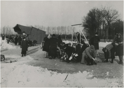195109 Het onderbinden van de schaatsen, 01-1940