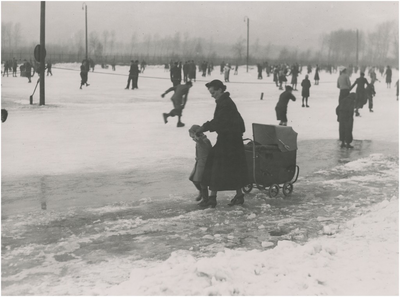 195112 Schaatsen: het recreatief schaatsen, sportpark, Aalsterweg. Moeder, kind en kinderwagen op het ijs, 12-1935