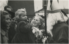 195382 Aankomst St. Nicolaas: St. Nicolaas begroet een bang meisje, 11-1950