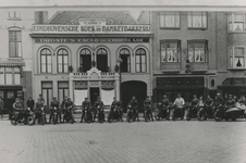 195621 Leden van Motorclub Het Zuiden poserend op hun motor voor bakkerij Verhoeven op de Markt, 1923-1927