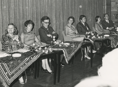 199064 Bloemen op tafeltjes met daarachter de vier vertrekkende wethouders en echtgenotes, 13-09-1974