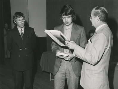 199069 Burgemeester van der Lee overhandigt Hans Jacobs drie boeken, links J. Verstegen de schrijver van het boek ...