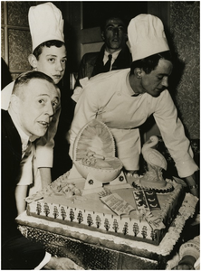 505297 Het aanbieden van een taart door Eindhovense Banketbakkersvereniging Sint Nicolaas aan de familie Busio, 28-03-1954