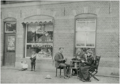 505410 J.M. Goppel legt een kaartje met het echtpaar Deckers voor zijn drankenfabriek, twee kinderen voor de winkel , 1902