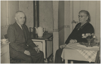 220749 Echtpaar Petrus van de Mortel en Maria Elisabeth Verleg bij de potkachel in hun woning, Heezerweg, 1950 - 1960