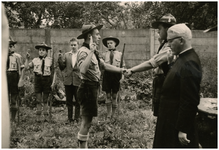 221054 Het afleggen van de eed door een padvinder tijdens zijn installatie, 1950 - 1960