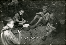 221057 Een serie van 11 foto's van het kamperen door padvinders. Voedselbereiding: het schillen van aardappelen door ...