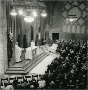 252199 Het voorgaan in de H. Mis in de Studentenkapel door deken Kaal. Op de voorste rij o.a. burgemeester H. Witte, ...