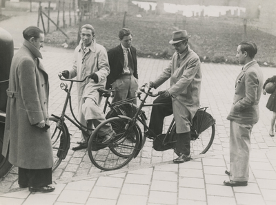 195852 Groepje mannen, twee met een fiets, 04 - 1937