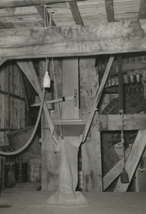 195931 Raderen, trechter waaronder een jute meelzak gevuld wordt, ernaast een gewicht aan een touw, 1966