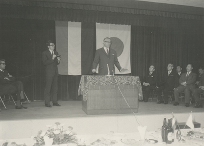 198650 Het toespreken door burgemeester Witte op een podium, links en rechts zittende heren vol aandacht, 04-1970