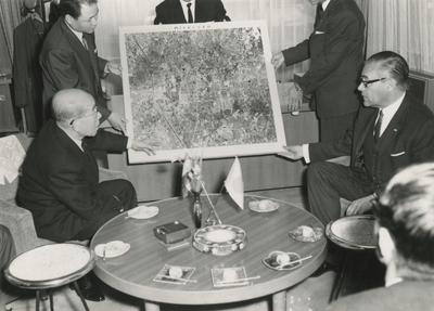 198654 Het tonen van een ingelijste topografisch kaart door onder andere burgemeester Witte, Mr. K. Matsushita geeft ...