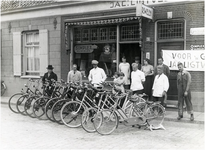 37 De tandems staan uitgestald voor de winkel. Tweede van links op de foto, Jac. Ligtvoet, in de deuropening zijn ...