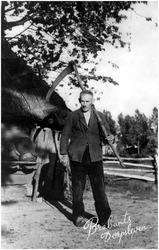 12743 Boer Toon van de Loo op Aarle, met zeis. Links van hem een schuur met druiprek voor melkbussen, 1934