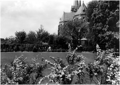12791 Tuin met bejaarden en enkele nonnen, met zicht op de achterzijde van de dorpskerk, 06-1967
