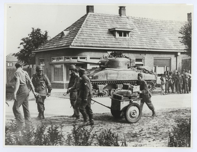 569166 De bevrijding Son en Breugel. Duitse krijgsgevangen helpen manschappen van de 101ste airborne divisie met het ...