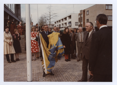 569591 De onthulling van de nieuwe gemeentevlag. Een lid van B & W met de vlag, 03-05-1977