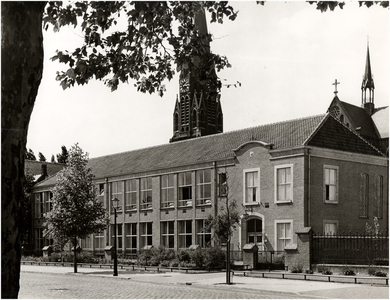 99051 R.K. meisjesschool, Pastoriestraat 108 met op de achtergrond de 'Sint-Petruskerk', 06-1956